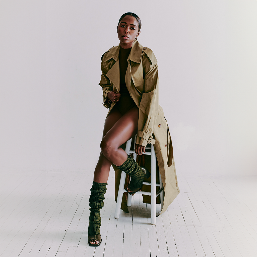 Daniella Shevel Onyx olive ankle boots paired with a textured sock and trench coat for bold styling.