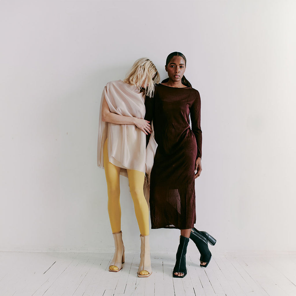 Model wearing Daniella Shevel Onyx ankle boots in camel mesh and leather, styled with bold yellow tights for a vibrant look.