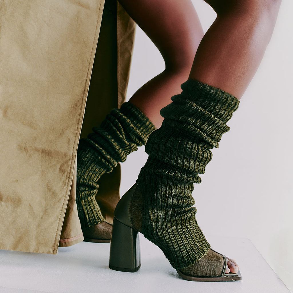 Daniella Shevel Onyx olive ankle boots styled with textured socks layered, showcasing their adaptability for cooler seasons.