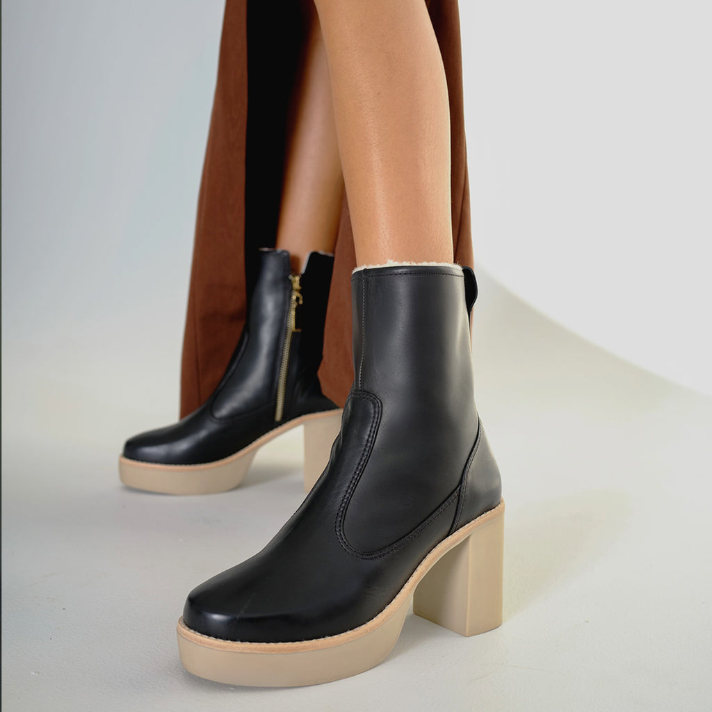 Daniella Shevel Aspen Shearling Boot in black waterproof and weatherproof with rubber lugg sole with brown staud dress close up on model