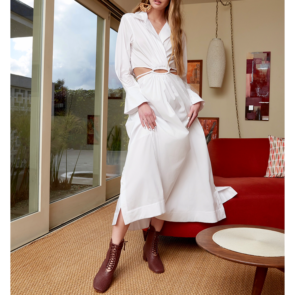 Daniella Shevel Coffee Brown Combat Bootie In Woven Leather With Memory Foam Insoles With White Dress and Orange Sofa in Los Angeles