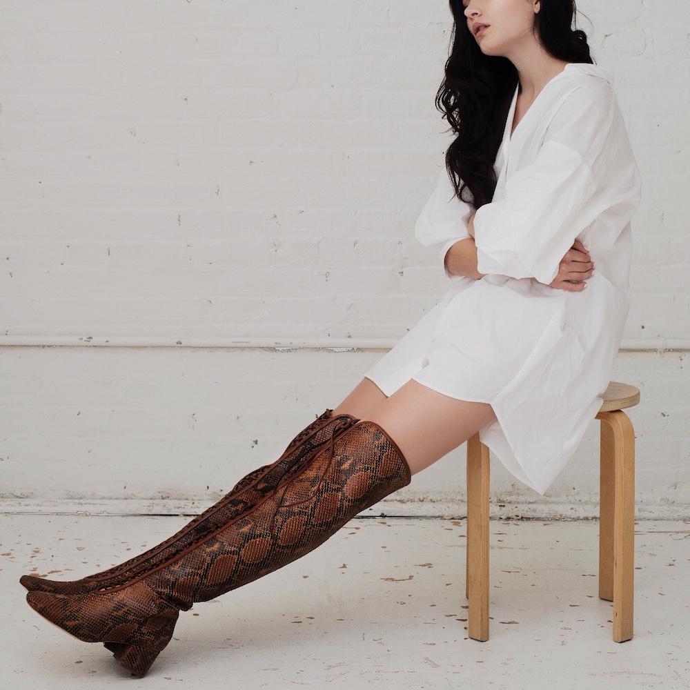Daniella Shevel Koa Brown Printed Snake Leather Boot with low Heel over the knee on model with white shirt dress look