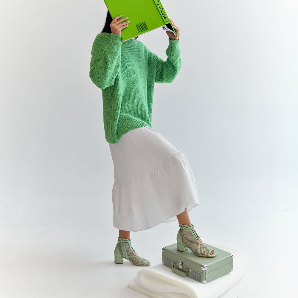 Daniella Shevel Mint Nola Mesh Bootie with white dress and green sweater holding Virgil Abloh Book
