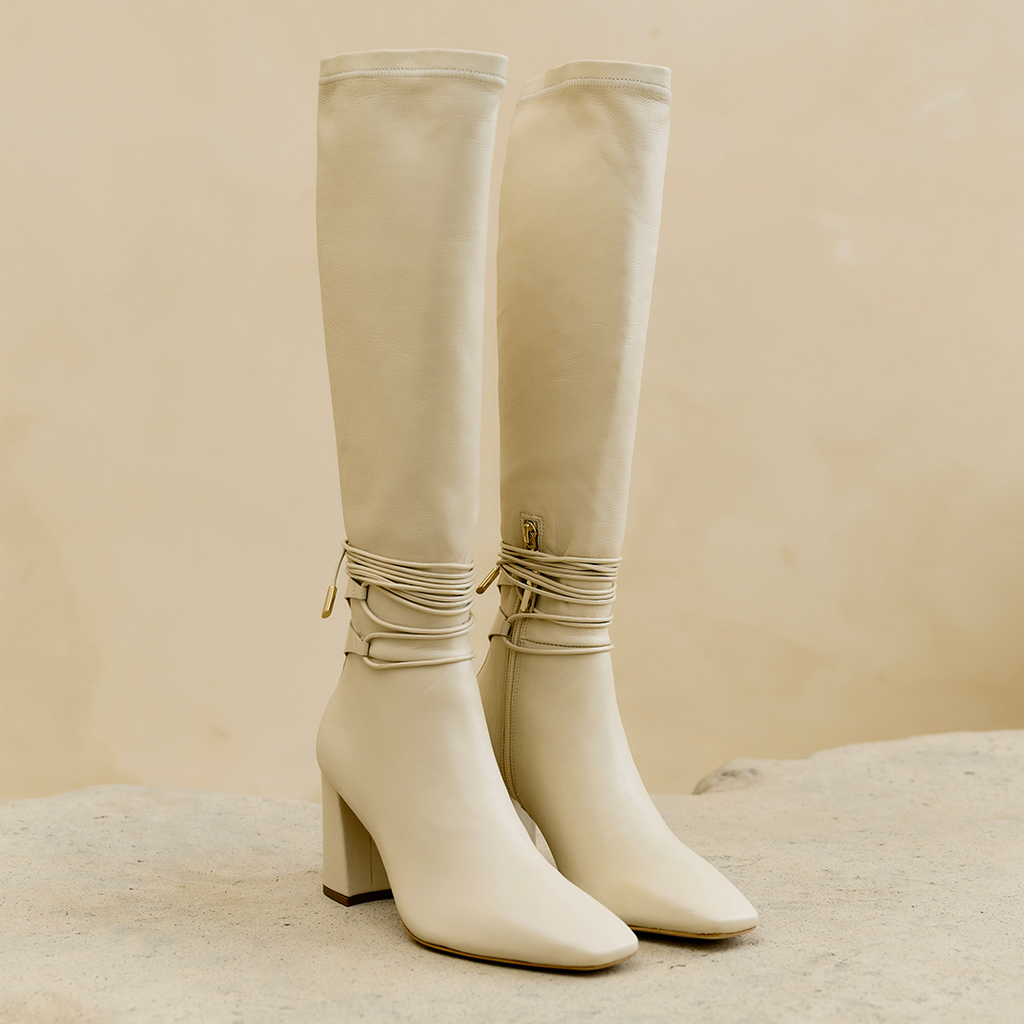 Daniella Shevel Cream Blonde Tall Shaft Boot in Leather stretch side view on stone ceramic table