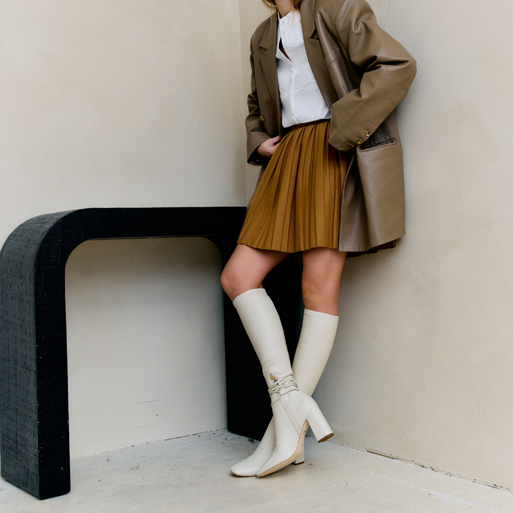Daniella Shevel Cream Blonde Tall Shaft Boot in Leather stretch with brown skirt and brown jacket